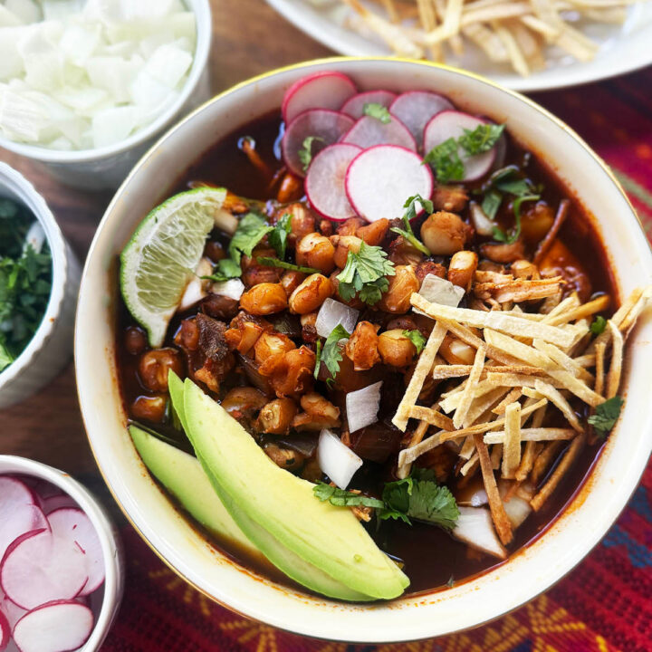Pozole Rojo served up in a bowl with fresh toppings