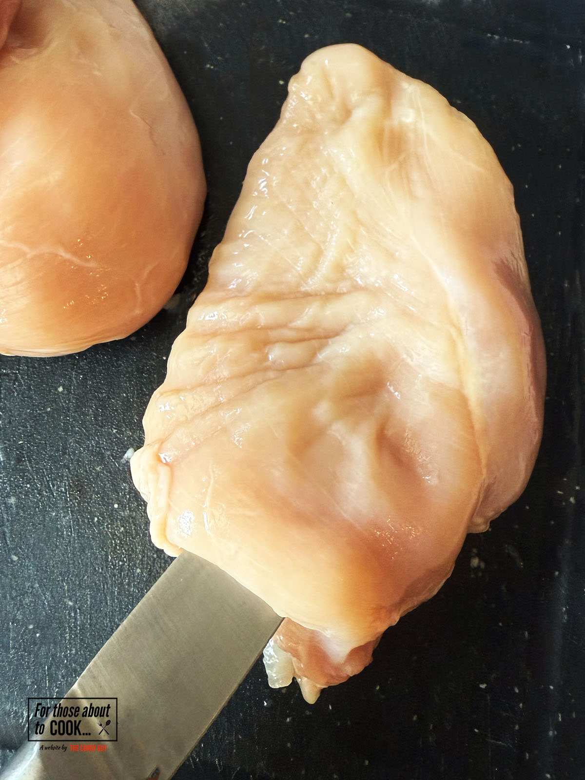 Knife piercing chicken kiev to make a pocket
