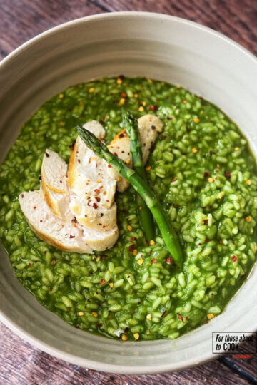 Risotto verde served with sliced chicken and asparagus sprigs