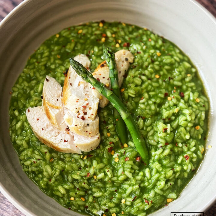 Risotto verde served with sliced chicken and asparagus sprigs