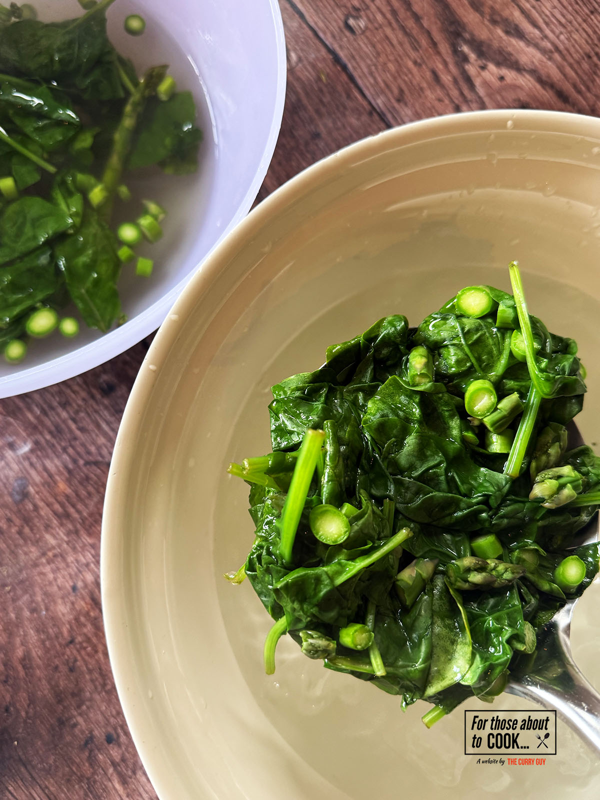 Spinach and asparagus blanching in boiling water then transferred to ice water